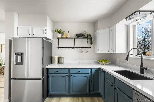 a kitchen with stainless steel appliances a sink a refrigerator and a counter