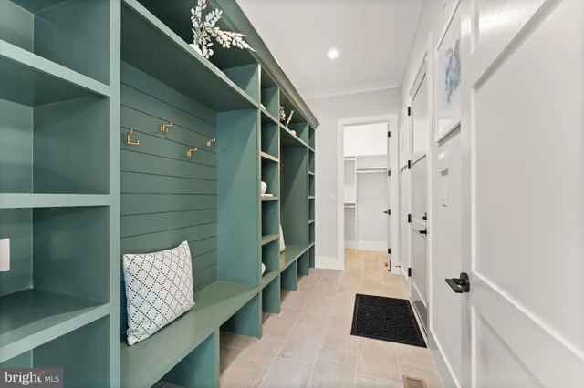 a view of a hallway with view of living room with wooden floor