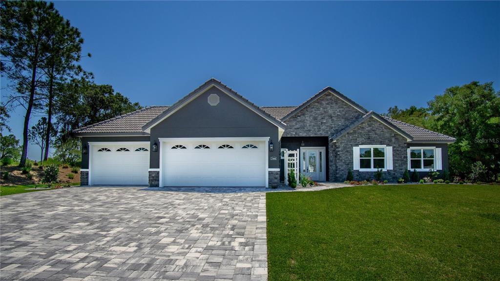 17694 Southwest 61st Ln Road Dunnellon, FL 34432 - Photo 1 of 1 a front view of a house with a yard and garage