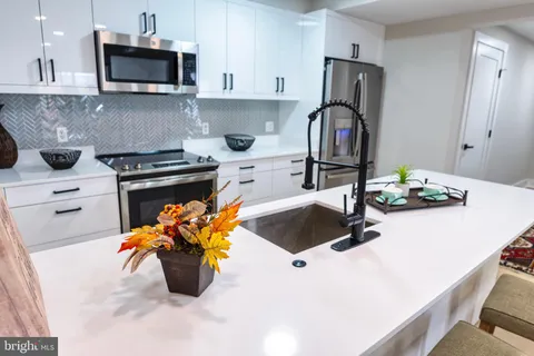 a kitchen with a stove a sink and a refrigerator