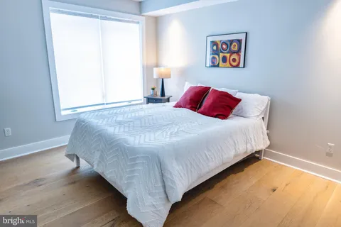a large white bed in a bedroom next to a lamp