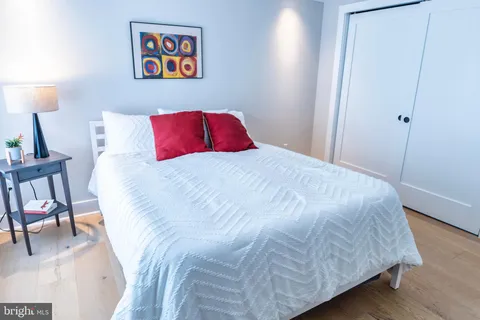 a bedroom with a bed and a lamp next to a window