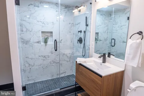 a bathroom with a sink a toilet and mirror