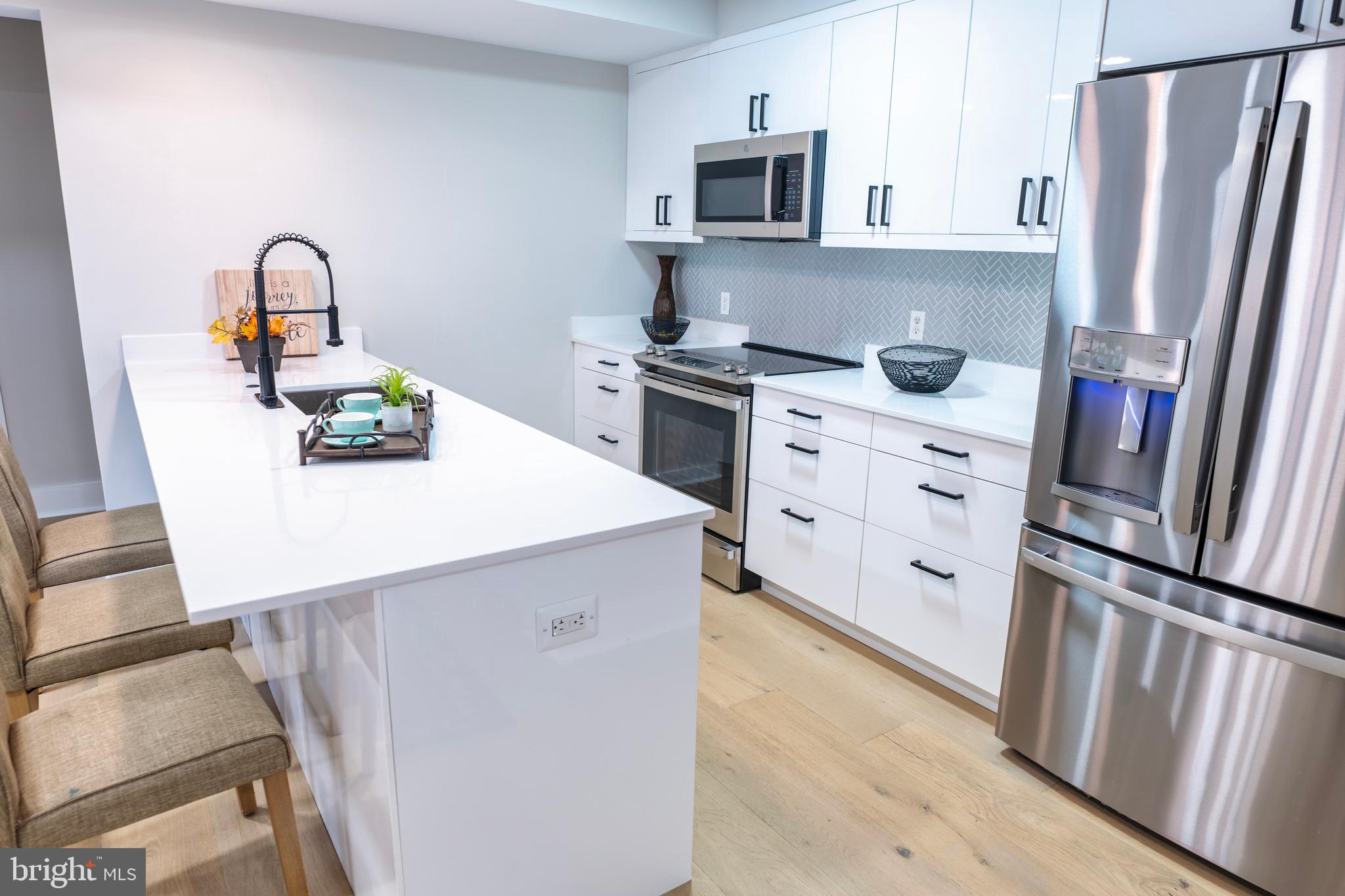 919 12th Street Northeast, Unit 202 Washington, DC 20002 - Photo 2 of 32 a kitchen with stainless steel appliances a refrigerator sink and white cabinets