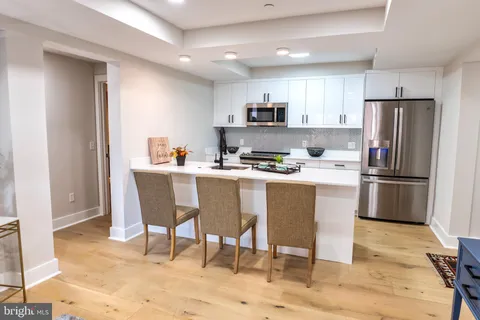 a kitchen with a dining table chairs refrigerator and cabinets