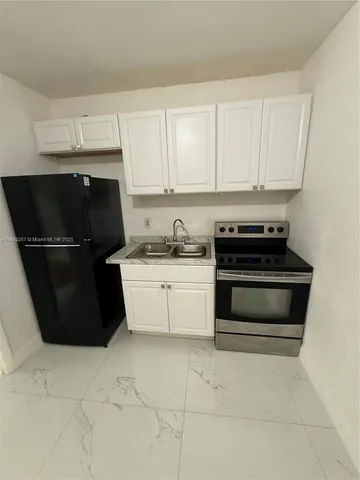 a kitchen with a refrigerator and a stove