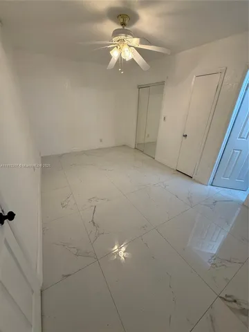 a view of an empty room with a ceiling fan