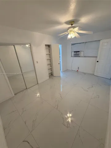 a view of a livingroom with a chandelier fan and hallway