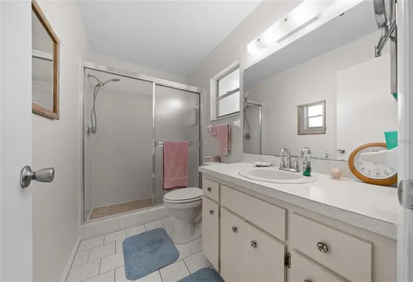 a bathroom with a toilet a sink a mirror a vanity and shower