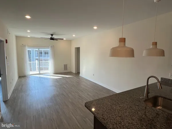 a view of a kitchen with a sink and dishwasher with wooden floor