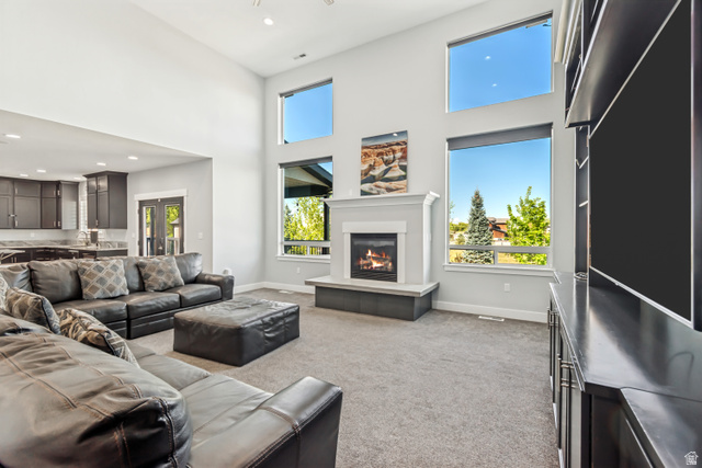 1526 South 500 West Mapleton, UT 84664 - Photo 7 of 54 Living room featuring carpet flooring, a glass covered fireplace, a high ceiling, recessed lighting, and french doors