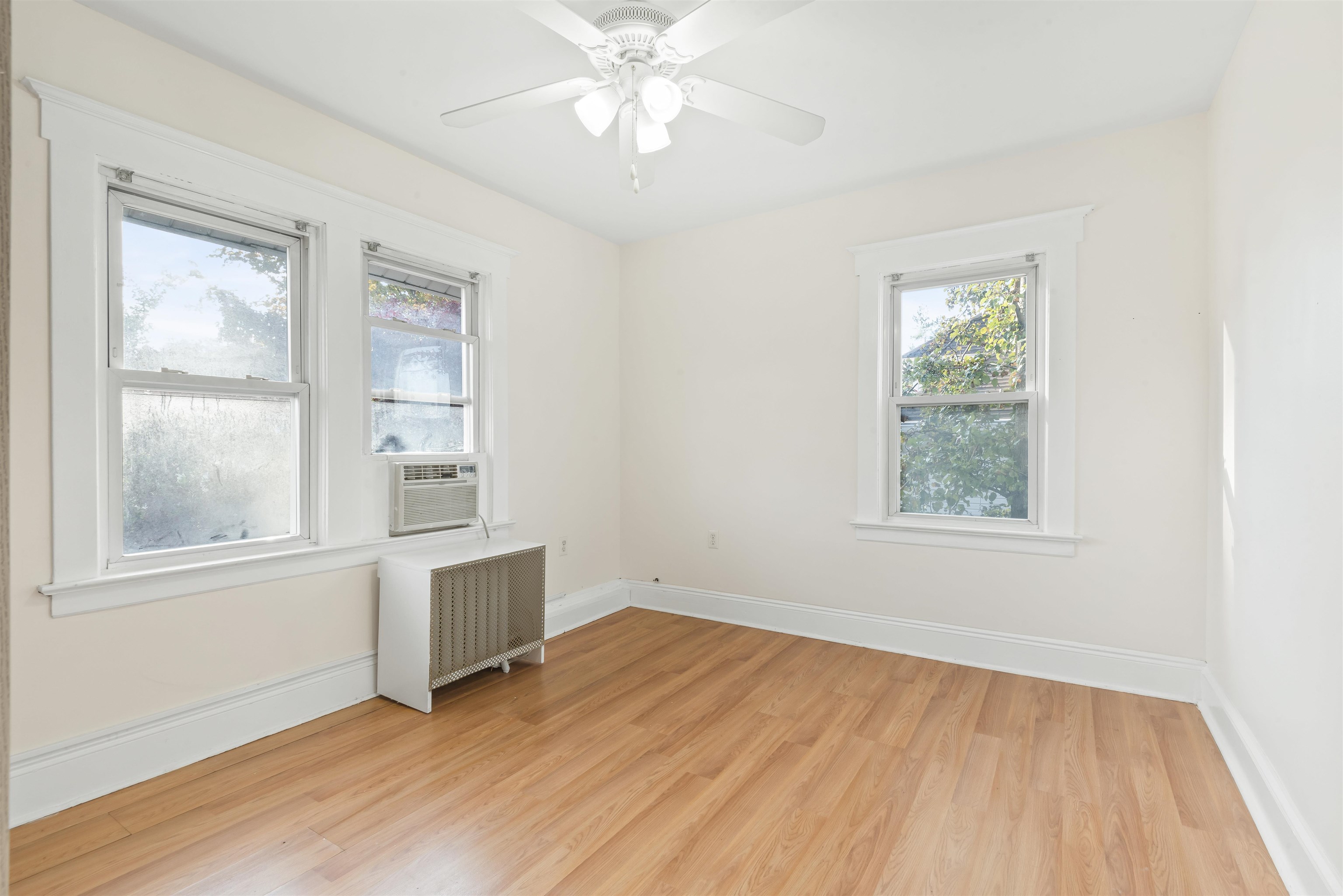 424 Lincoln Avenue Rutherford, NJ 07070 - Photo 12 of 30 an empty room with wooden floor chandelier fan and windows