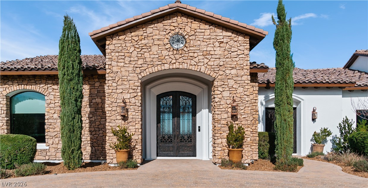 1123 Christian Road Henderson, NV 89002 - Photo 8 of 94 A grand entrance welcomes with ornate double doors set in a striking stone facade.