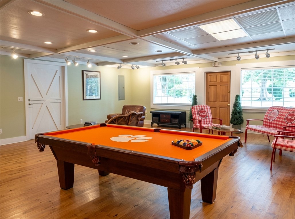 Rich hardwood flooring and integrated recessed lighting define this versatile recreation space.