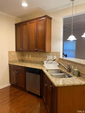 a kitchen with granite countertop a sink and a wooden cabinets