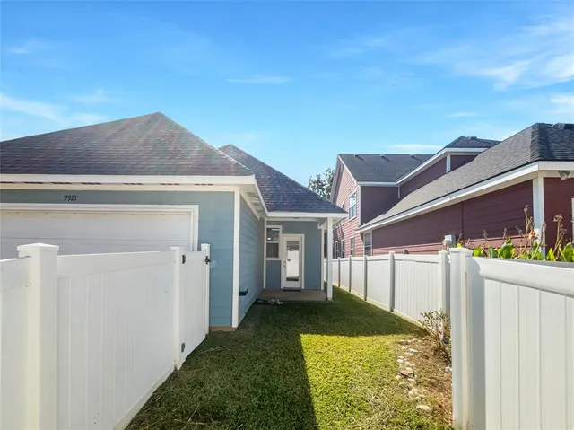 a view of a hallway with wooden floor and a bathroom