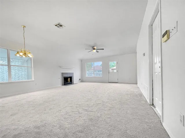 an empty room with windows and fireplace