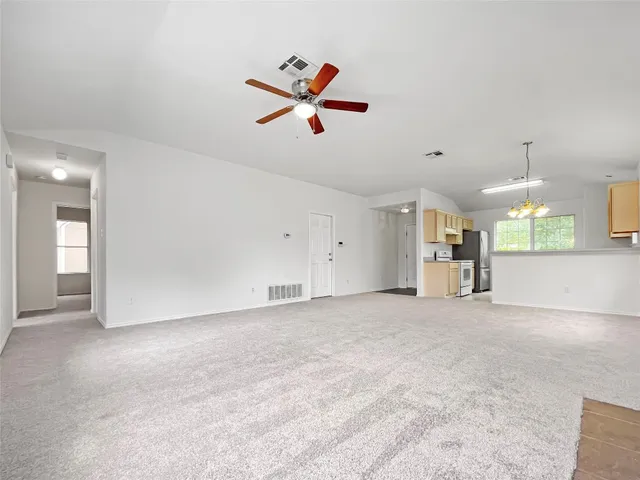 an empty room with a window and a ceiling fan