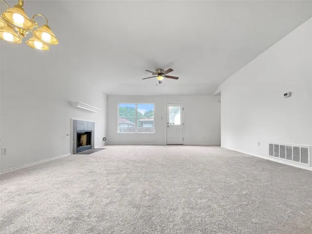 a view of an empty room with a window and fireplace