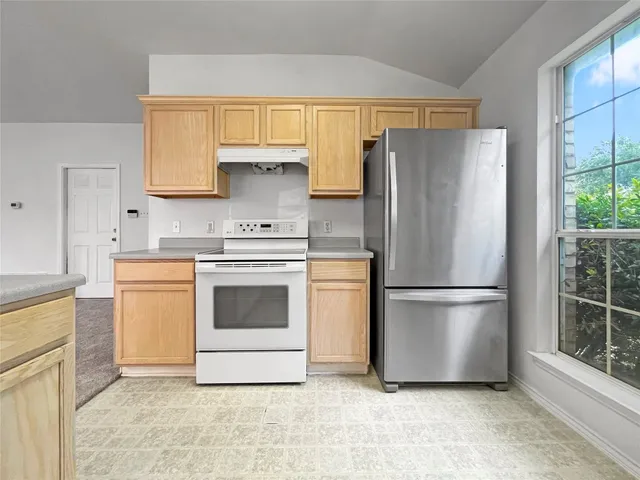 a white refrigerator freezer and a stove sitting inside of a kitchen