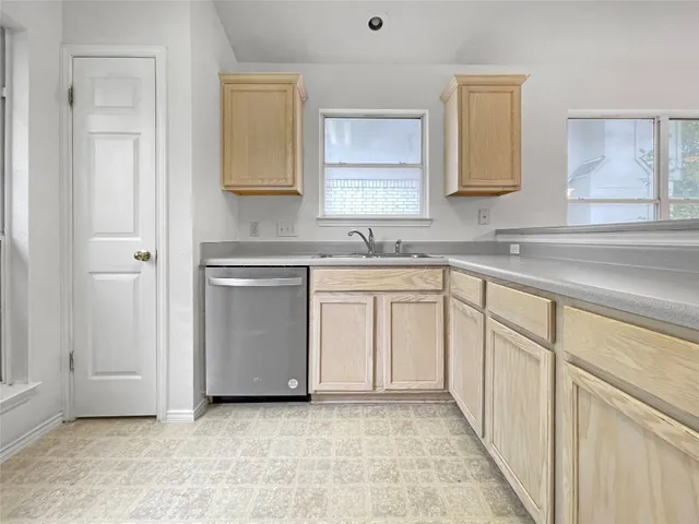 a kitchen with white cabinets and sink