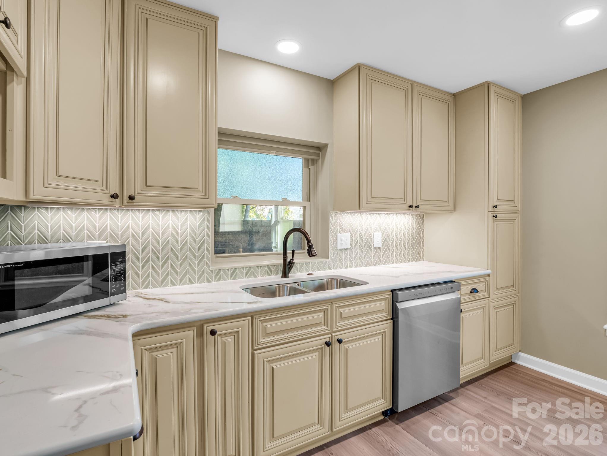 44 Jervey Road, Unit 4C Tryon, NC 28782 - Photo 10 of 35 a kitchen with stainless steel appliances granite countertop a sink and dishwasher with white cabinets