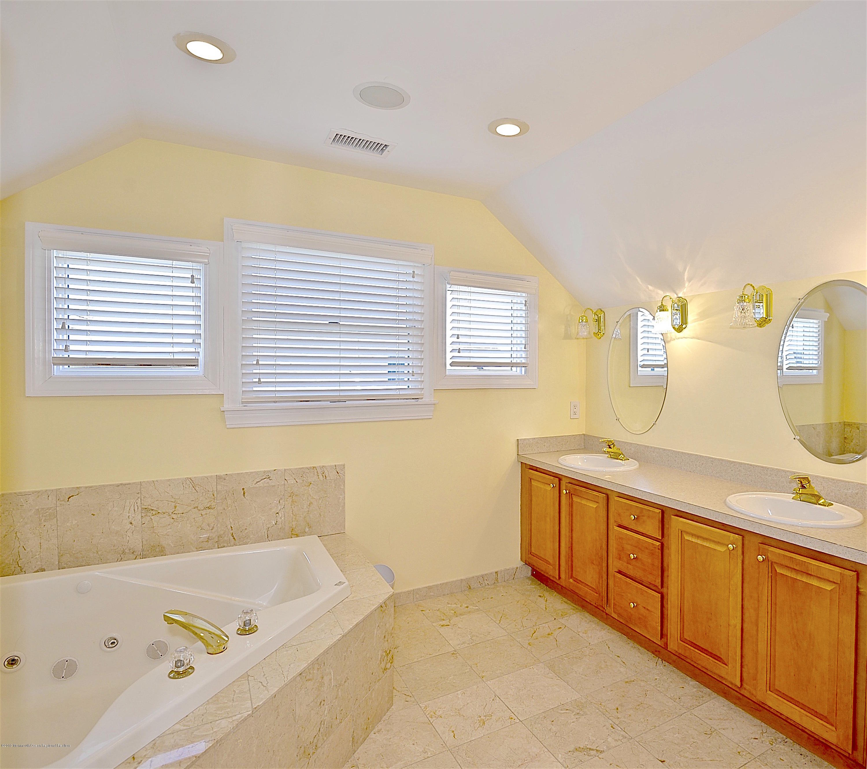 209 1st Avenue Spring Lake, NJ 07762 - Photo 1 of 19 a bathroom with a tub sink and mirror