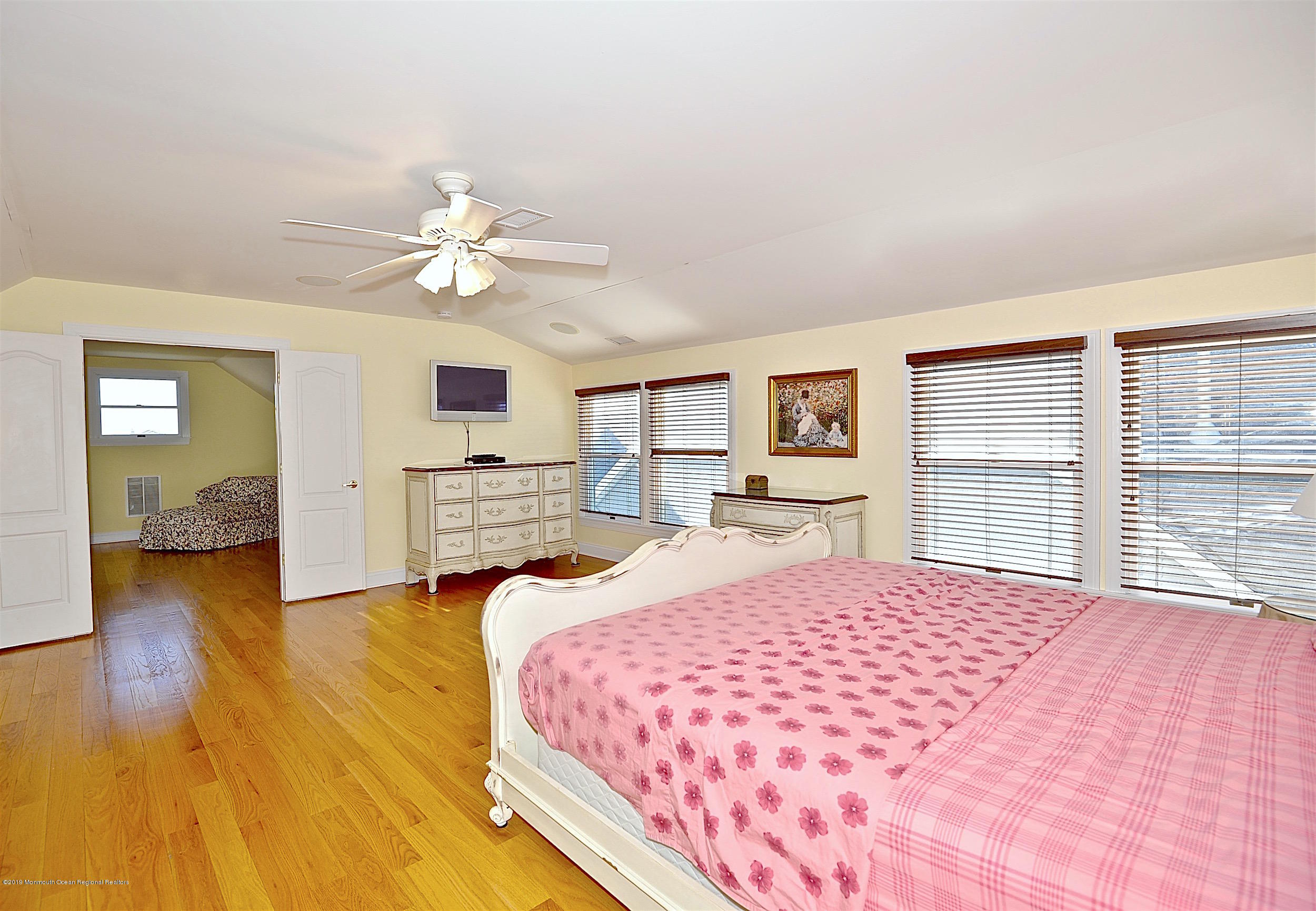 209 1st Avenue Spring Lake, NJ 07762 - Photo 16 of 19 a bedroom with a large bed and a chandelier
