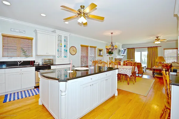 a kitchen with a sink a counter top space and living room view