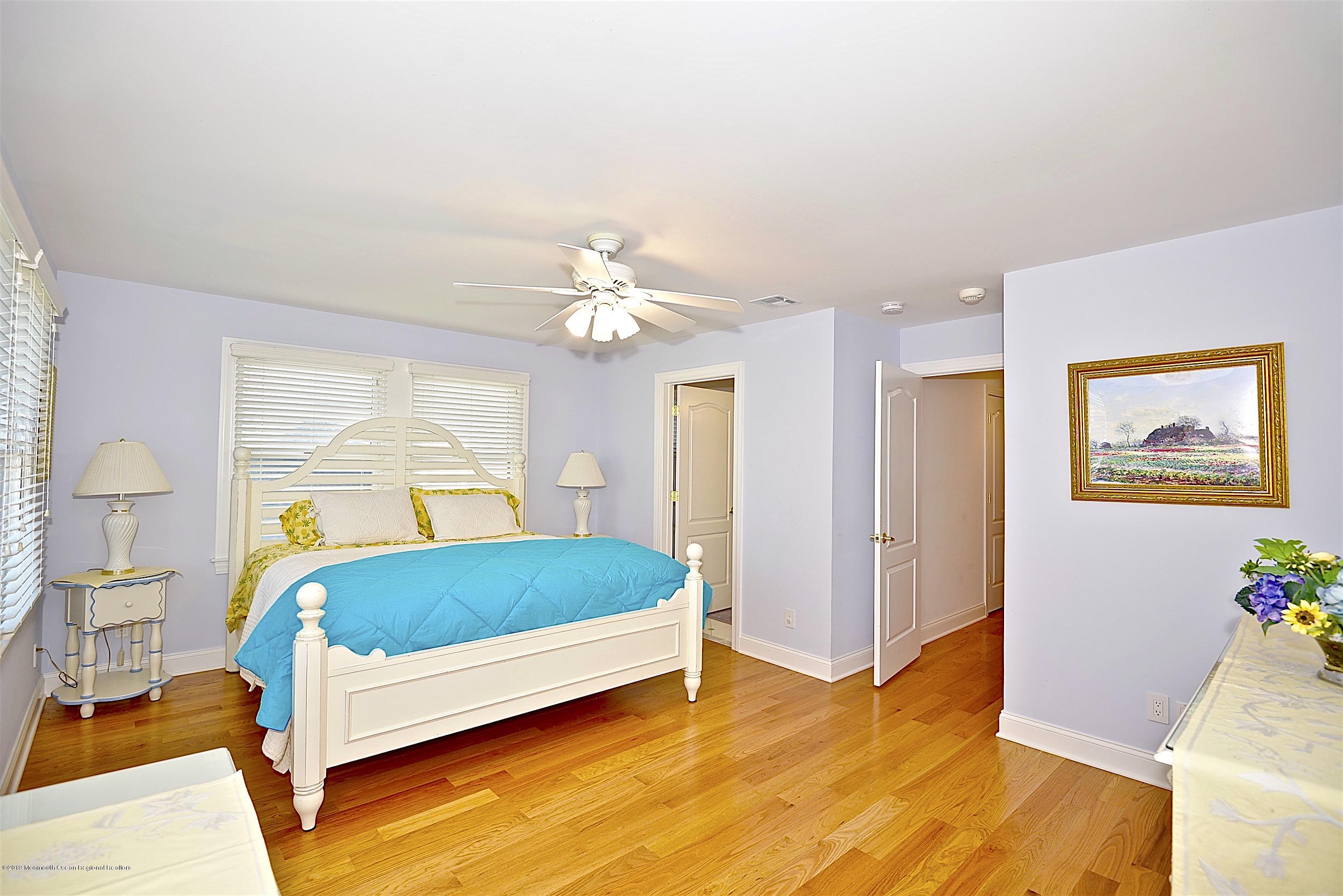 209 1st Avenue Spring Lake, NJ 07762 - Photo 9 of 19 a bedroom with a bed and a chandelier