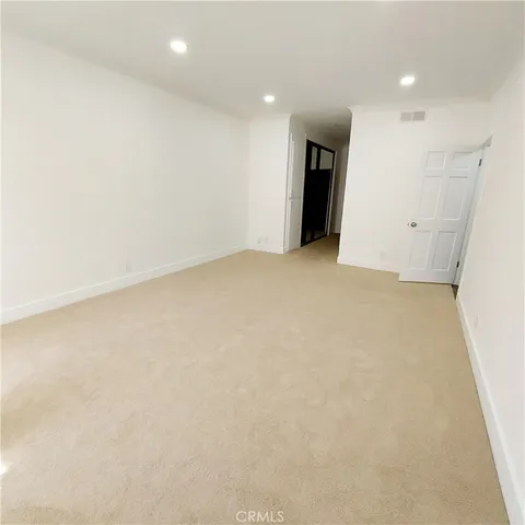 an empty room with an entryway and cabinet