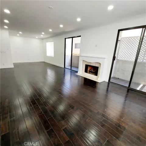 an empty room with wooden floor and fireplace
