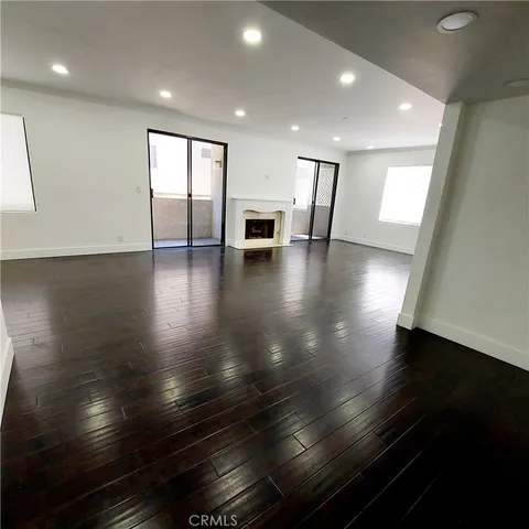 a view of empty room with wooden floor and fireplace