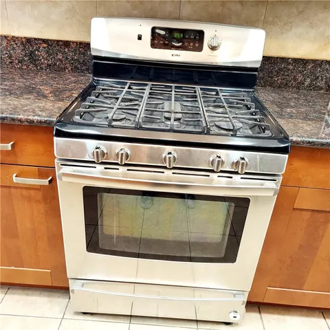 a stove top oven sitting inside of a kitchen