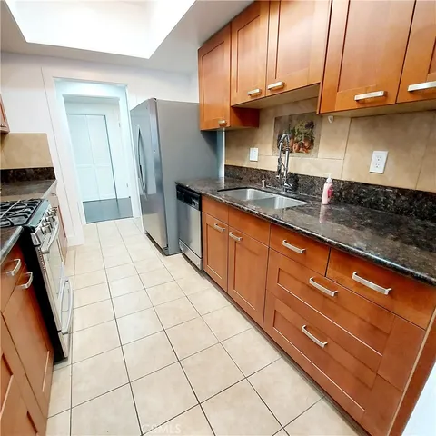 a kitchen with stainless steel appliances granite countertop a sink stove and cabinets