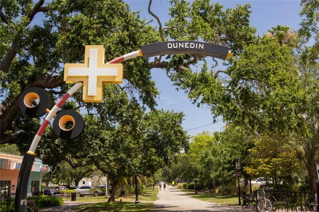 a front view of a building with trees and retail shops