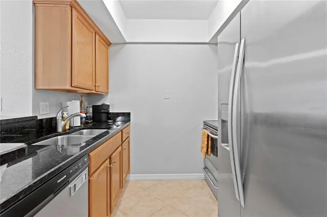 a kitchen with stainless steel appliances granite countertop a refrigerator and a stove top oven