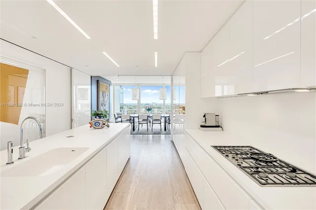 a large white kitchen with a large window
