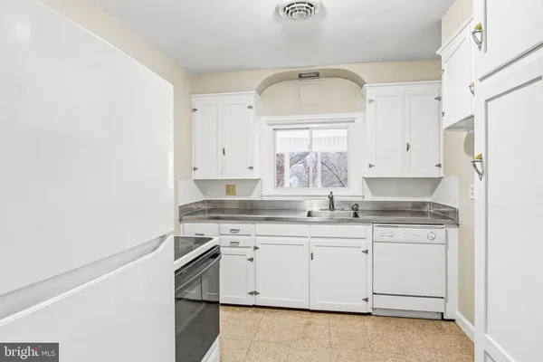 a kitchen with granite countertop white cabinets and white appliances