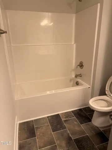 a bathroom with a toilet and a mirror