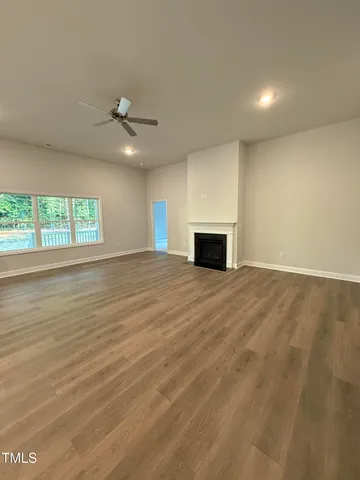 an empty room with windows and ceiling fan