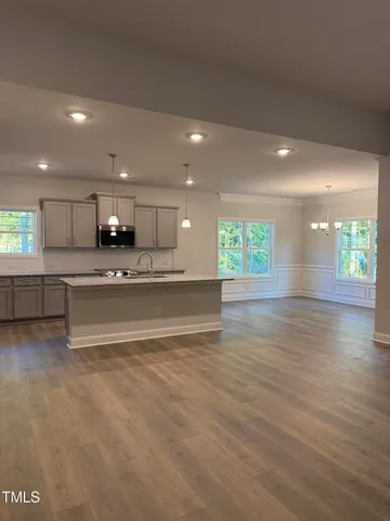 a large kitchen with stainless steel appliances kitchen island a large counter top and a wooden floors