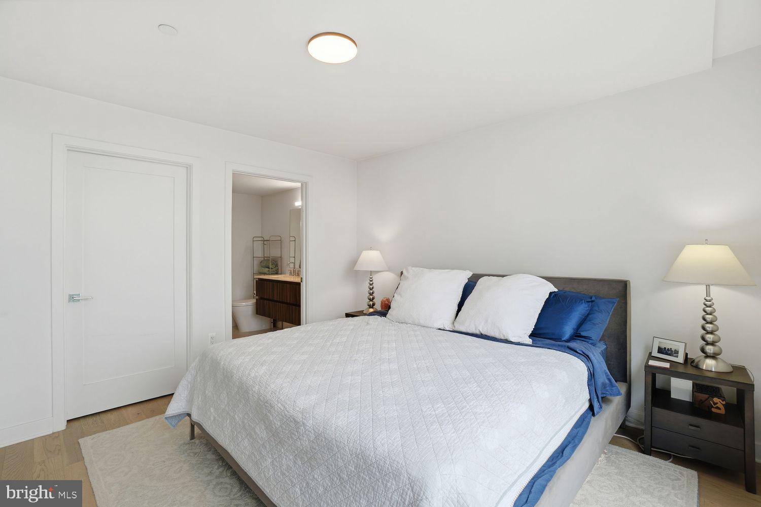 37 L Street Southeast, Unit 902 Washington, DC 20003 - Photo 15 of 43 a bedroom with a bed and lamp