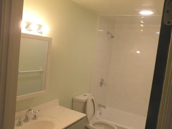 a view of an empty room with wooden floor and closet