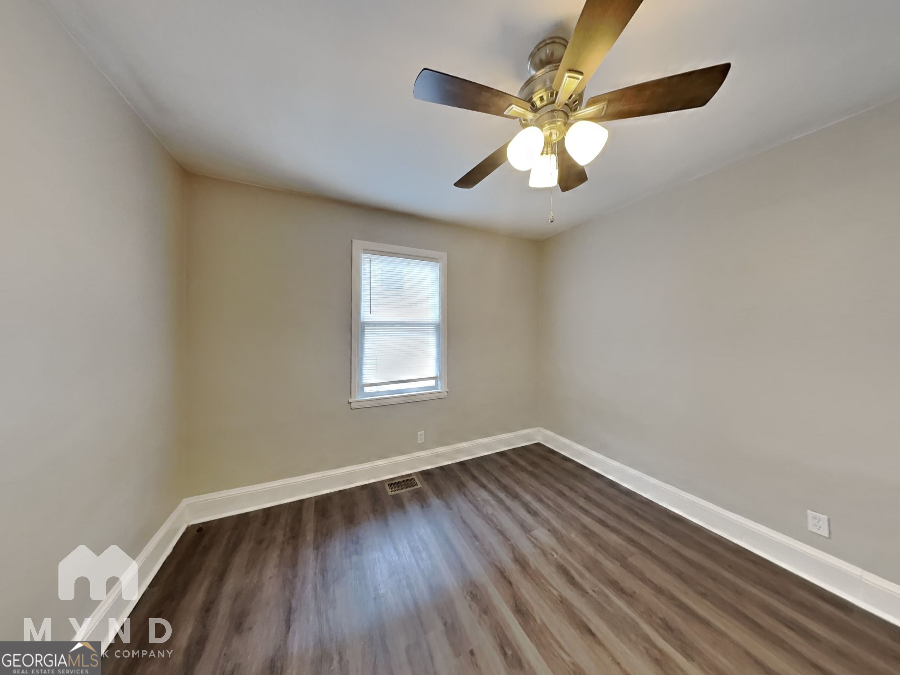 1284 Westmont Road Southwest Atlanta, GA 30311 - Photo 15 of 20 an empty room with wooden floor fan and windows