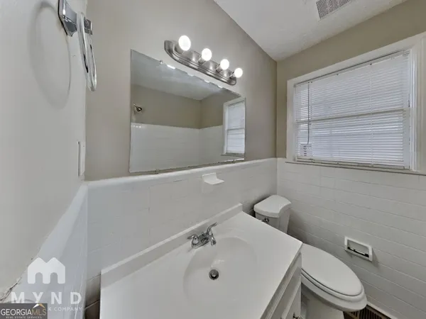 a bathroom with a toilet a sink and mirror