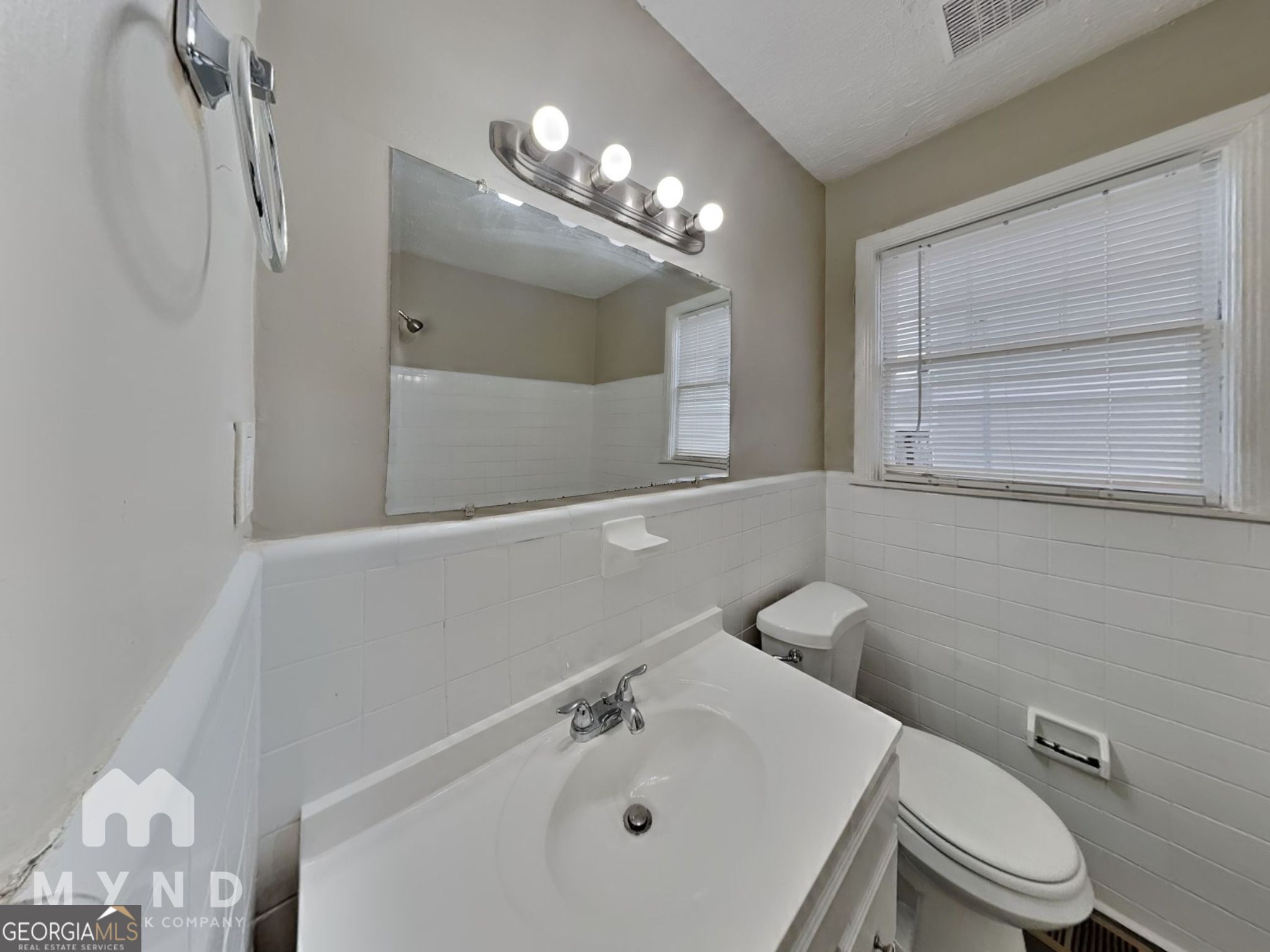 1284 Westmont Road Southwest Atlanta, GA 30311 - Photo 16 of 20 a bathroom with a toilet a sink and mirror
