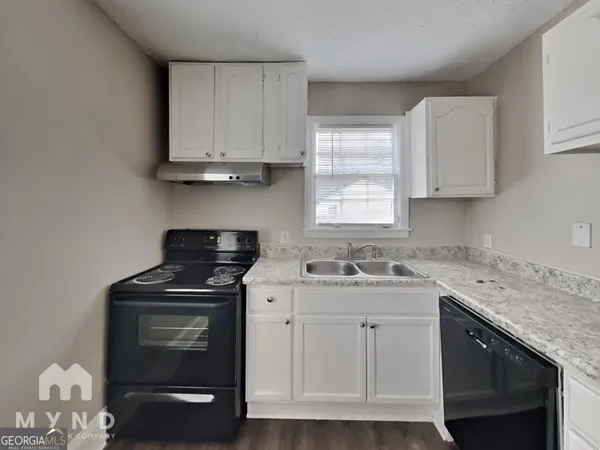 a kitchen with cabinets appliances a sink and a window