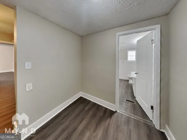 a view of a room with wooden floor and a bathroom