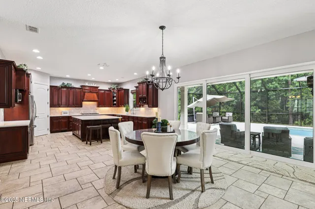a dining room with furniture a chandelier and wooden floor